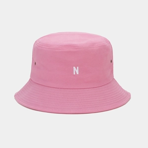Détail d'un chapeau bob rose en coton avec broderie lettre N blanche et œillets