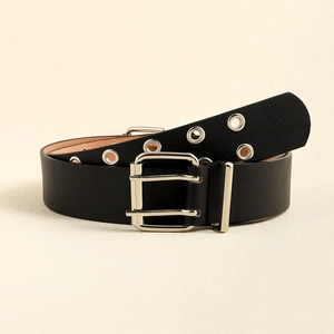 Close-up of black leather belt with silver double-prong buckle and metal eyelets