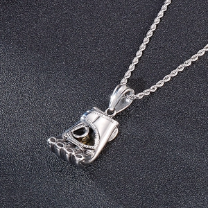Close-up of polished silver boxing glove pendant on a twisted rope chain necklace