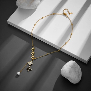 Golden Y-necklace with interlocking rings, black and white butterflies, and a pearl drop