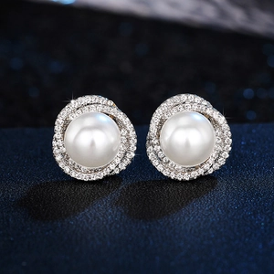 Detailed close-up of pearl stud earrings with zircon flower wrap design on dark background