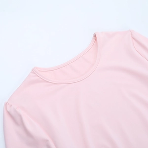 Gros plan détaillé du tissu rose lisse de la robe et des coutures nettes de l'encolure