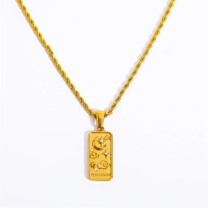 Close-up of golden rectangular pendant with moon, star details and THE MOON engraving