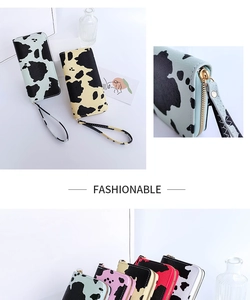 Detailed macro view of cow print wallet with secure metal zipper and wrist strap detail