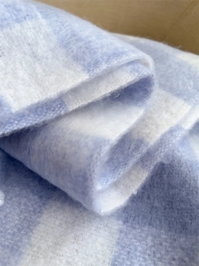 Close-up of blue and white plaid faux cashmere scarf showing thick soft wool texture