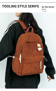 Brauner Cord-Rucksack mit niedlichen Bärenanhängern in der Rückansicht am Modell