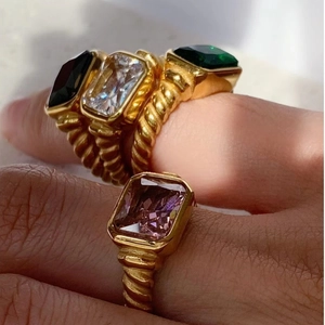 Goldene Ringe mit Seilstruktur und bunten Zirkonia im Smaragdschliff in Schwarz und Grün