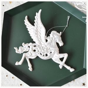 Close-up of white glitter pegasus ornament on a green tray for Christmas decor