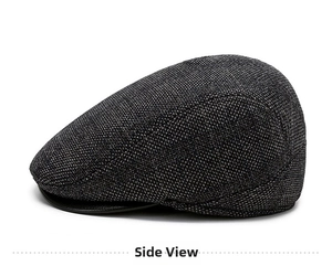 Side view detail of a dark gray plaid tweed flat cap with refined brim piping accents
