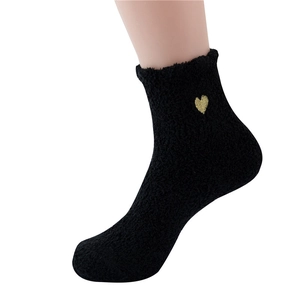 Close-up of soft black coral fleece sock featuring a delicate gold heart embroidery