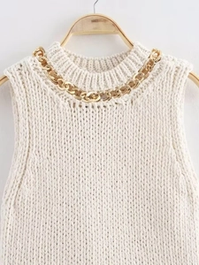Close-up of cream chunky knit vest with gold chain detail on the neckline