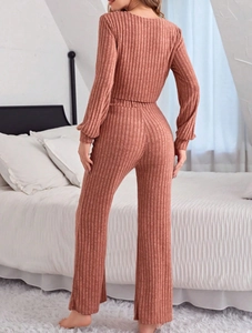 Detail of brick red ribbed pajama set featuring wide-leg trousers and soft knitted fabric