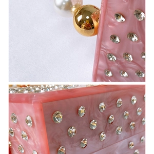 Detail of pink marble acrylic evening bag with sparkling rhinestones and pearl handle
