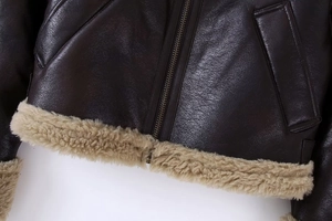 Détail de la veste en cuir marron foncé avec bordure en laine d'agneau et fermeture éclair