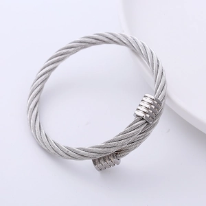 Detailed view of silver stainless steel twisted cable bangle with smooth metal end caps