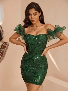 Détail d'une robe verte à paillettes avec épaules dénudées et manches à volants