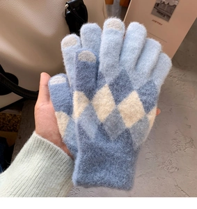 Close-up of blue diamond patterned knit gloves with touchscreen tips and plush texture