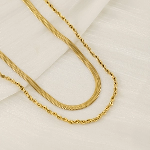 Detail of gold double-layer necklace featuring herringbone and twisted rope chain textures