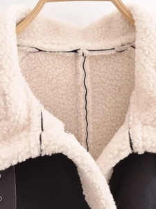 Close-up of contrast faux shearling collar and black leather jacket details