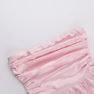 Detail of pink satin mini dress showing pleated off-shoulder neckline and silky texture