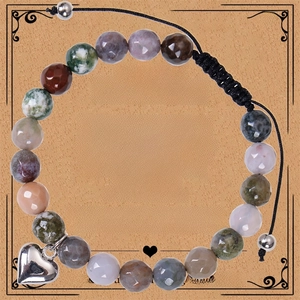 Macro view of beaded natural stone bracelet with a polished heart charm on a gift card