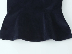 Detailed macro view of dark navy corduroy fabric texture and stitching on the skirt hem