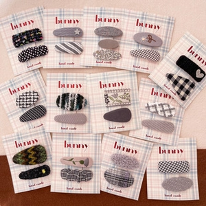 Flat lay view of fabric hair clip sets with bow and floral patterns on display cards