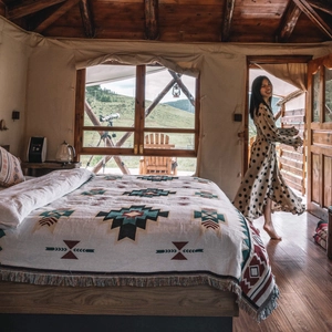 Detail of bohemian geometric woven blanket with delicate fringe trim in a rustic wood cabin