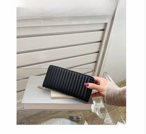 Detail of black PU leather long wallet featuring vertical quilted texture and gold zipper