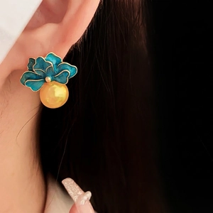 Vintage blue enamel flower earrings with golden pearl drops on a model for a luxury look