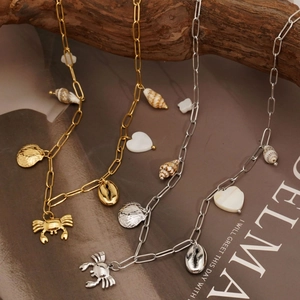 Summer ocean necklace with crab, shell, and conch pendants on a stylish paperclip chain