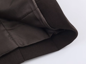 Close-up of high-quality diagonal twill fabric texture and stitching on brown suit jacket