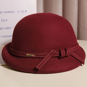 Detail of dark burgundy wool cloche hat with white contrast stitching and bow