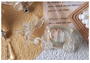Detail of transparent iridescent Pegasus carriage ornament with elegant white ribbon strap