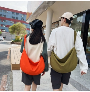 Outdoor shot of large capacity oxford crossbody bags in orange and olive green