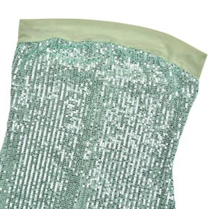 Dettaglio del tessuto di paillettes verde menta con cuciture in mesh su un abito