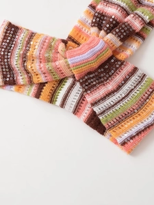 Detail aus bunt gestreiftem Strickstoff mit glänzenden Pailletten und Häkeltextur