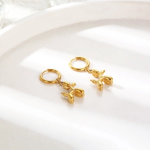 Polished gold balloon dog drop earrings with stainless steel hoops on white background