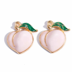 Detail of peach fruit charms with pink enamel and green leaves for DIY jewelry making