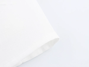 Dettaglio macro del tessuto bianco a trama crespa sull'orlo di un abito corto
