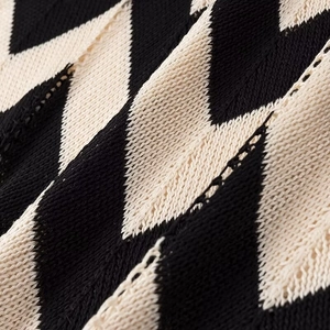 Makroaufnahme der Chevron-Strickstruktur in schwarz-beigem Wellenstreifenmuster