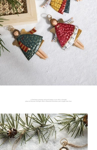 Detail of painted metal Christmas angel ornament with pine cones and green needles