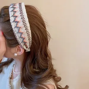 Serre-tête tricoté au style ethnique avec broderie porté par un mannequin sous lumière douce