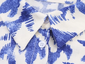 Close-up of the shirt collar with blue tie-dye print and white button detail