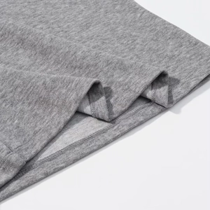 Detailed close-up of grey knitted fabric texture and high-quality hem stitching