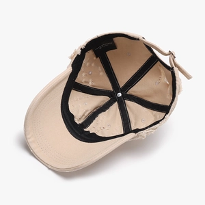Inside view of beige distressed cotton baseball cap with six-panel stitching and metal buckle