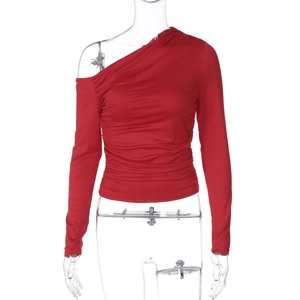 Détail du haut court asymétrique rouge à une épaule avec plis texturés et manche longue