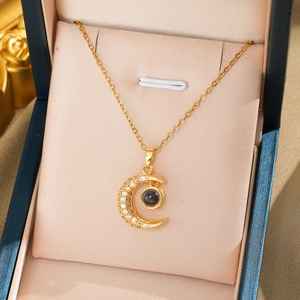 Macro detail of gold moon pendant with zirconia and 100 languages love projection stone