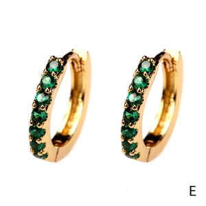 Detail of 18K gold plated hoop earrings featuring sparkling green zircon stones