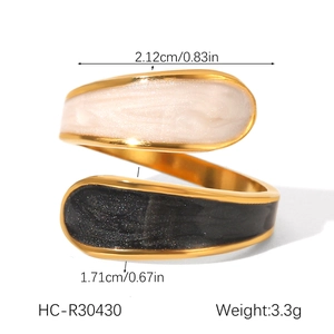 Detailed view of irregular gold ring with black and white enamel drip and size specs